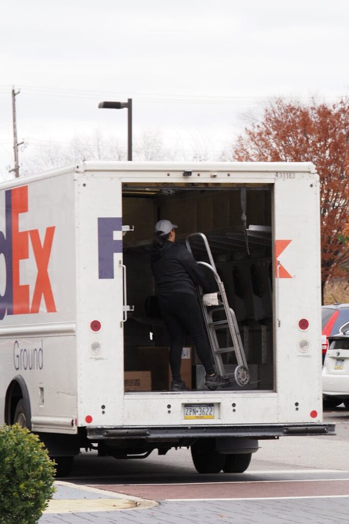 Courier unloading packages from FedEx truck in urban area. Efficient package delivery in Willow Grove, PA.