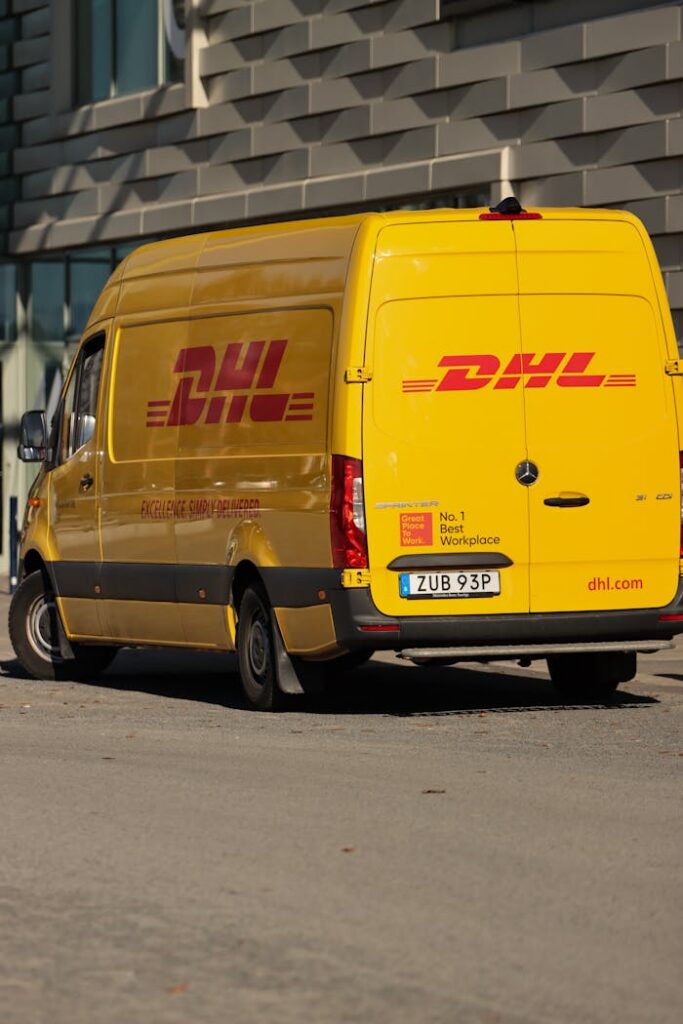 Yellow DHL delivery truck parked in the city streets of Jönköping, Sweden on a sunny day.