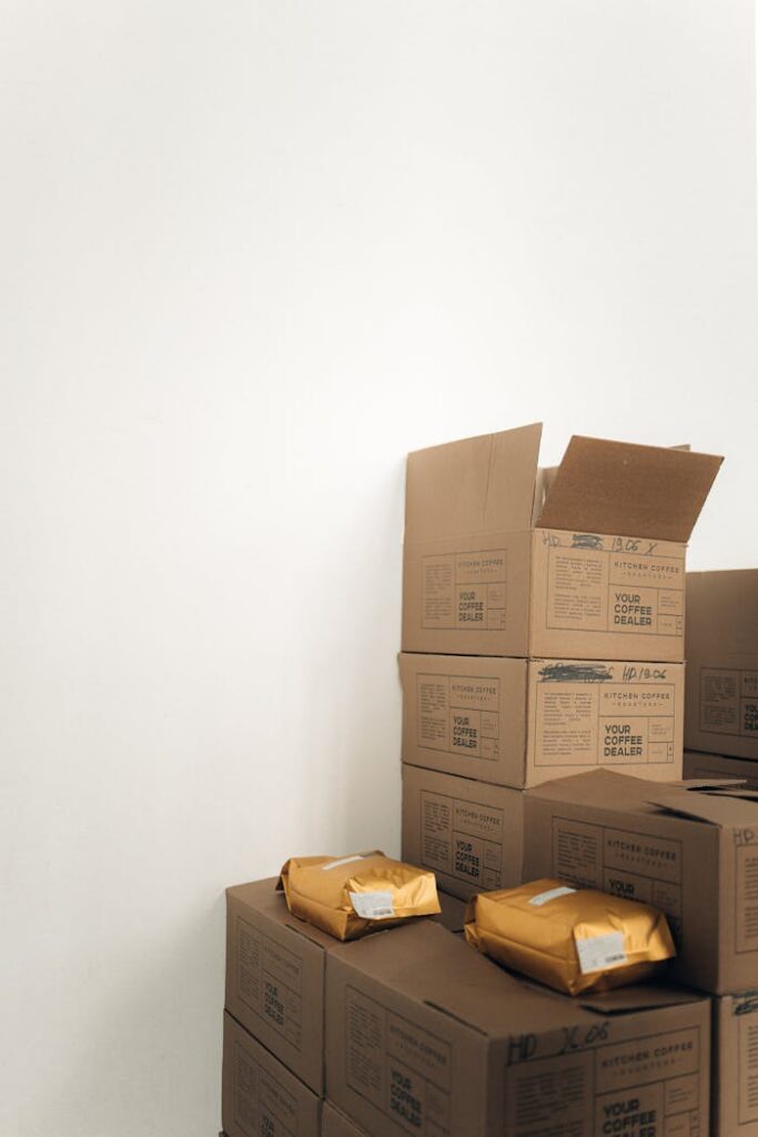 Cardboard boxes and packages stacked neatly beside a white wall. Ideal for moving, storage concepts.