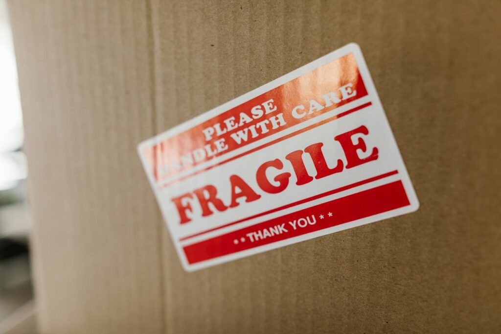 Close-up of a cardboard box with a 'fragile' sticker indicating careful handling.